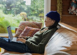 Why Full Fibre is Essential for UK Businesses in 2025 A woman sitting on a couch working on her laptop