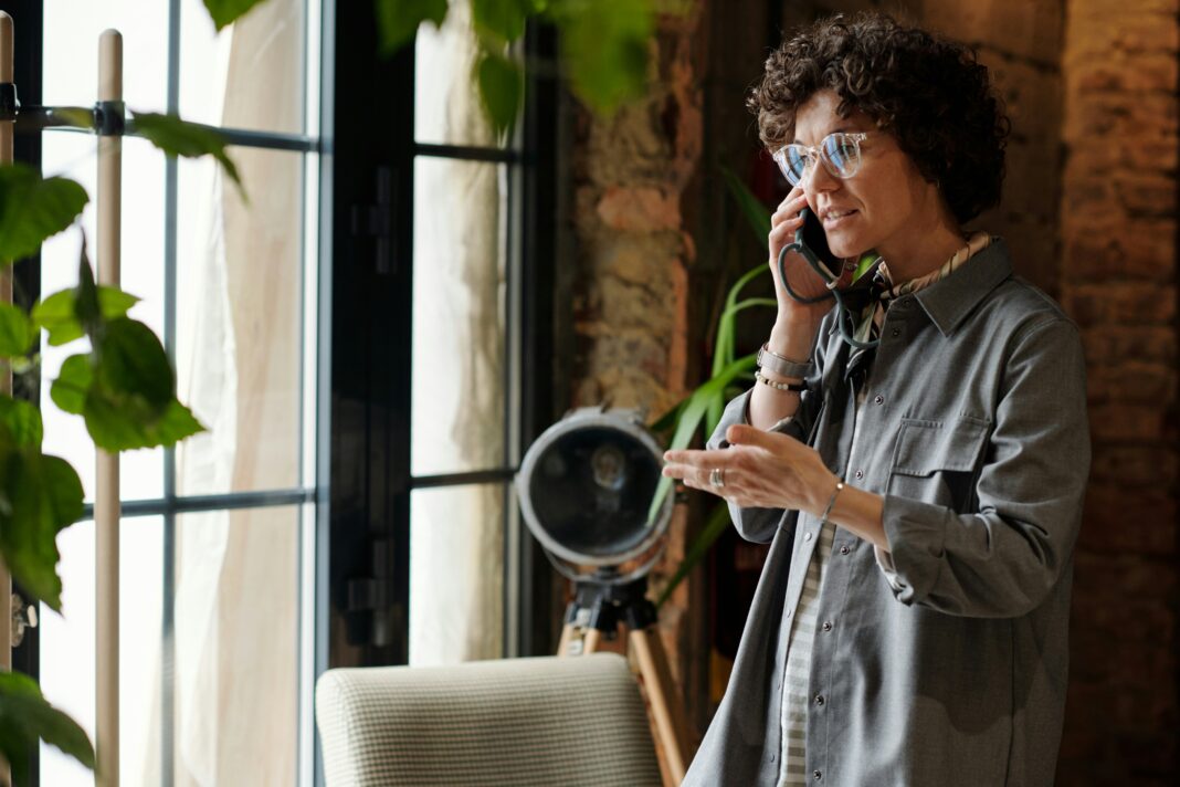 Can I Use an eSIM and a Physical SIM At the Same Time? A woman standing in a studio talking on the phone