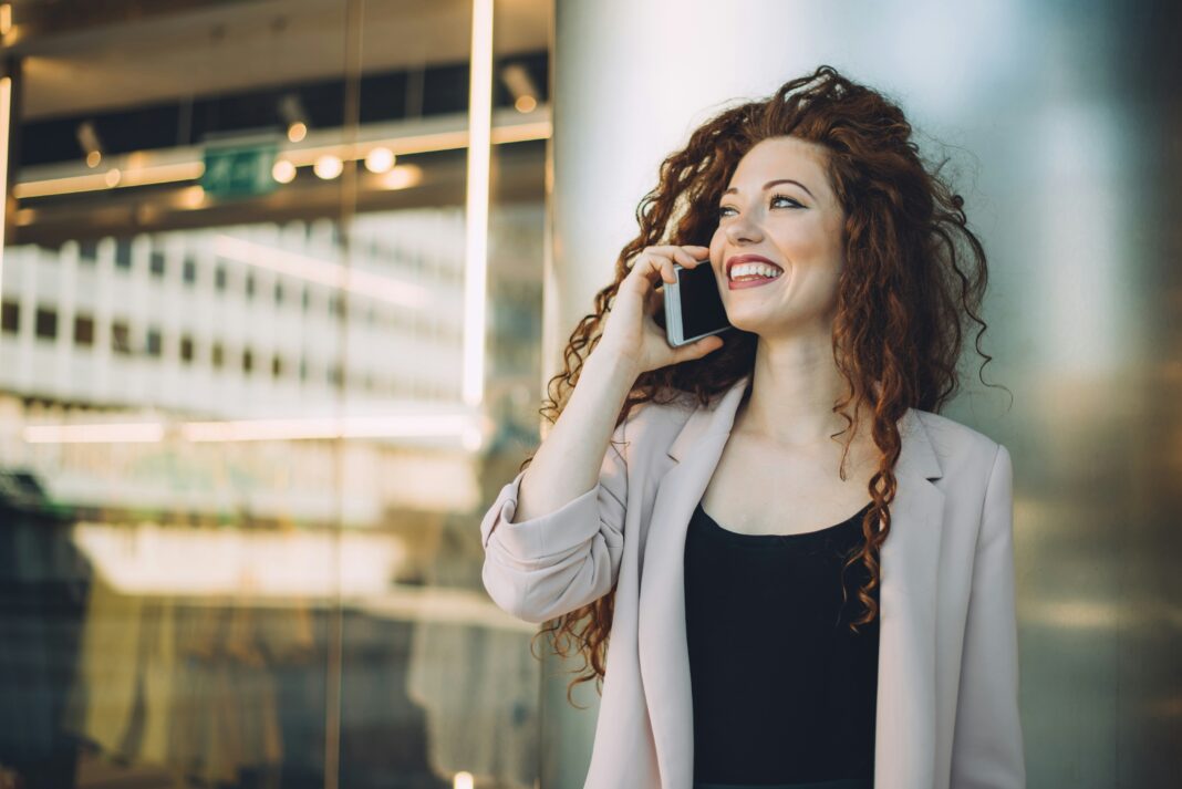 A woman standing outside an office talking on the phone