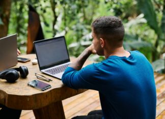 How Full Fibre Could Transform Remote Work for UK Residents A man sitting at a wooden table outside working on his laptop