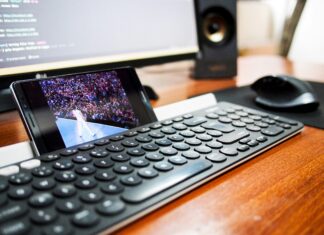 How Much Should I Be Paying For Full Fibre Broadband? A photo of a phone resting behind a keyboard streaming a video