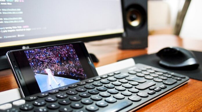 How Much Should I Be Paying For Full Fibre Broadband? A photo of a phone resting behind a keyboard streaming a video