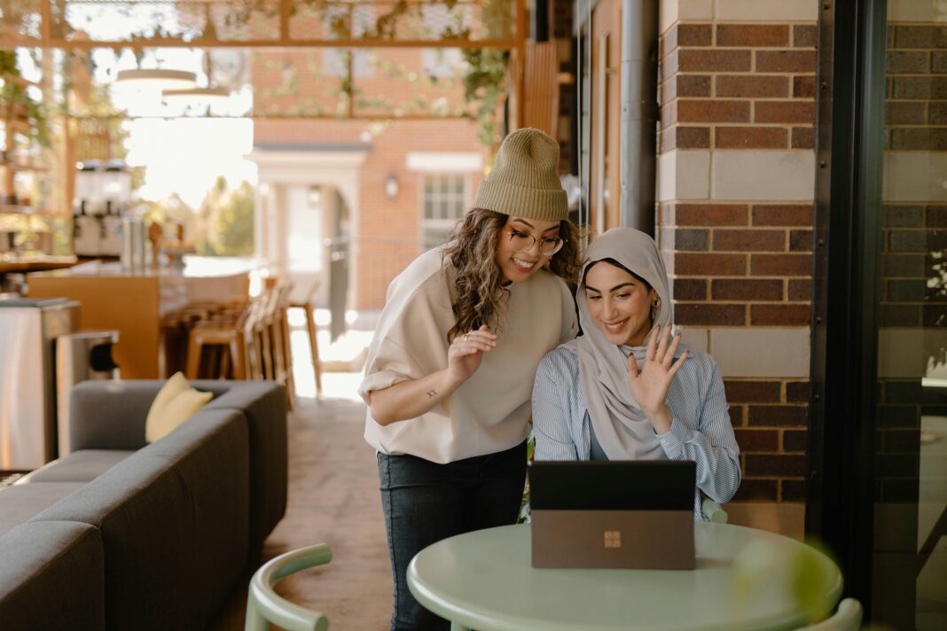 How to Scale Your VoIP System As Your Business Grows Two women looking at a laptop while in a coffee shop