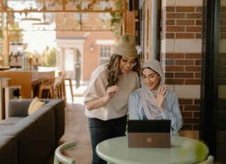 How to Scale Your VoIP System As Your Business Grows Two women looking at a laptop while in a coffee shop