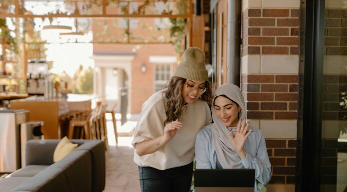 How to Scale Your VoIP System As Your Business Grows Two women looking at a laptop while in a coffee shop