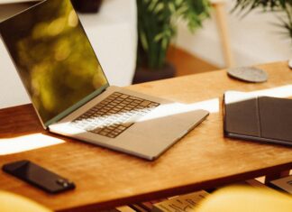 Understanding Which UK City Has The Fastest Internet Speeds A photo of a laptop sitting on a wooden desk with a beam of sunlight shining over it