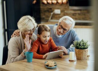What Are the Benefits of AI Integration in VoIP Systems? Grandparents and their grandson sitting at a table with coffee video calling on a tablet