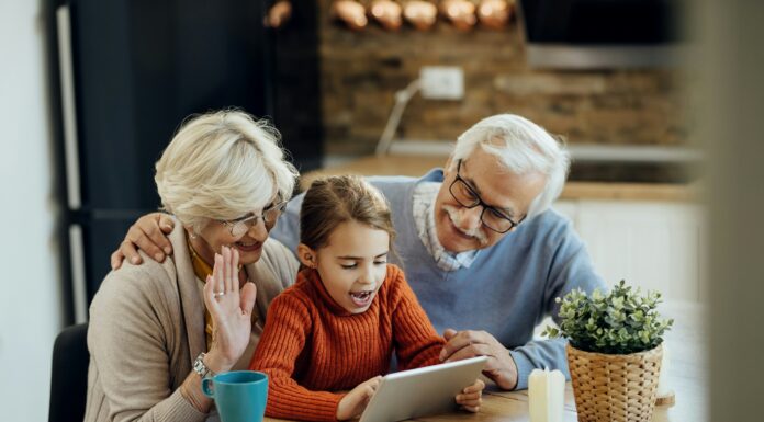 What Are the Benefits of AI Integration in VoIP Systems? Grandparents and their grandson sitting at a table with coffee video calling on a tablet