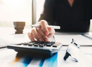 Can UK Financial Institutions Use VoIP for Secure Communication? woman-typing-on-a-calculator-with-a-pen-in-her-hand