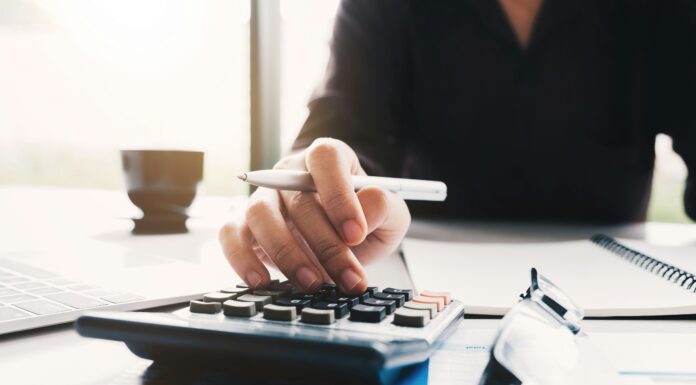 Can UK Financial Institutions Use VoIP for Secure Communication? woman-typing-on-a-calculator-with-a-pen-in-her-hand