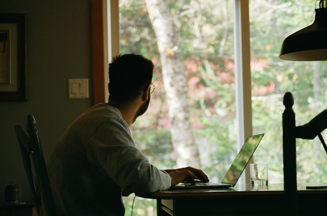 man-sitting-at-his-desk-looking-out-a-window