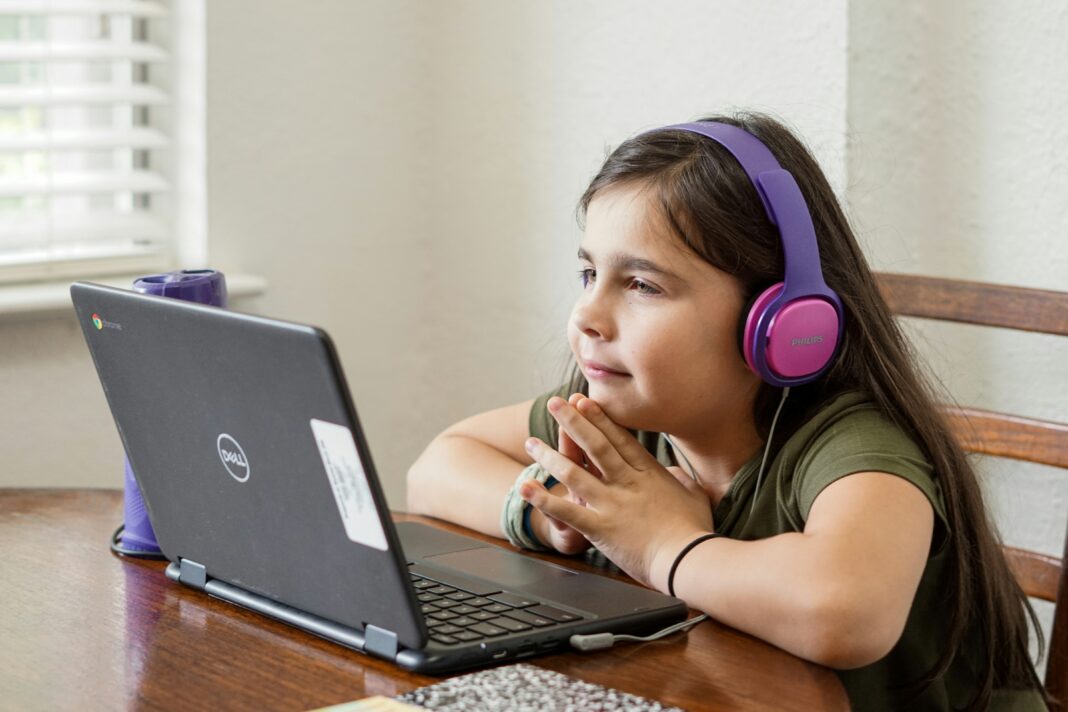 girl-with-headphones-on-attending-class-on-her-laptop