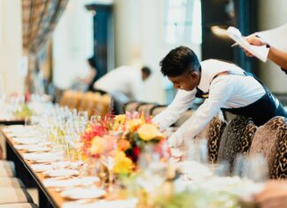 Why Hospitality Businesses Are Moving to VoIP Systems a-man-setting-a-table-in-a-restaurant