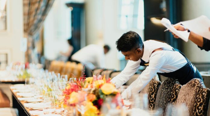Why Hospitality Businesses Are Moving to VoIP Systems a-man-setting-a-table-in-a-restaurant
