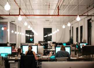 How AI Transcription Enhances VoIP Meeting Efficiency large-modern-office-with-employees-on-large-computer-screens