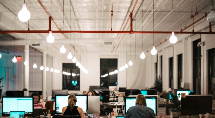 How AI Transcription Enhances VoIP Meeting Efficiency large-modern-office-with-employees-on-large-computer-screens