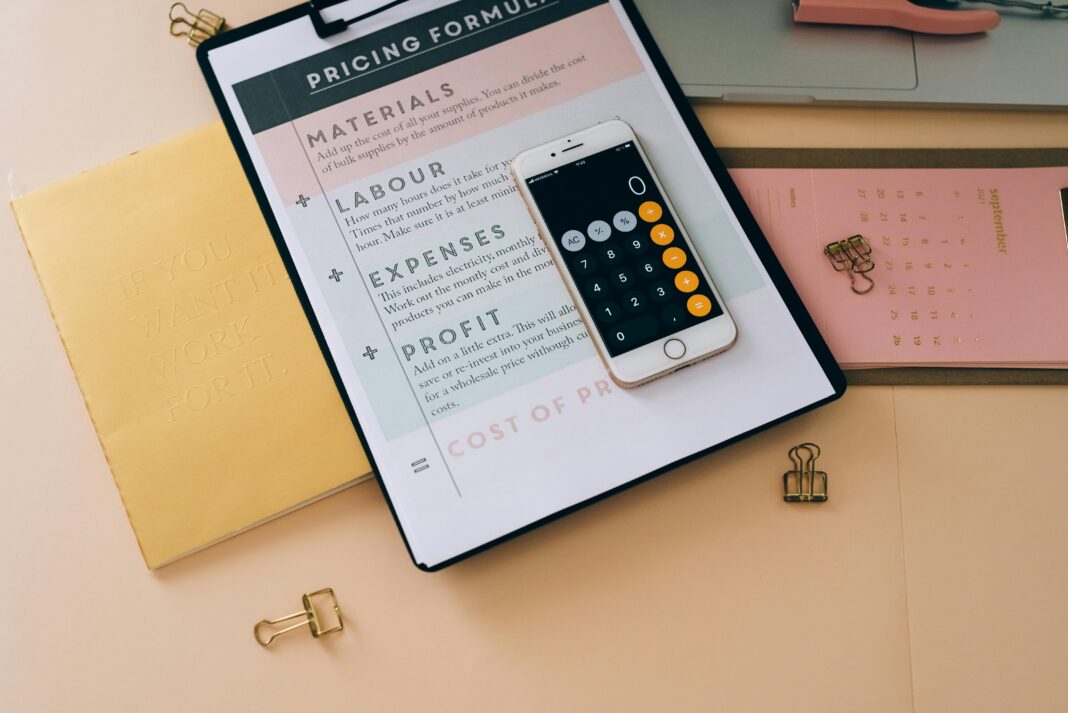 desk-with-clipboard-pricing-formula-and-phone-calculator