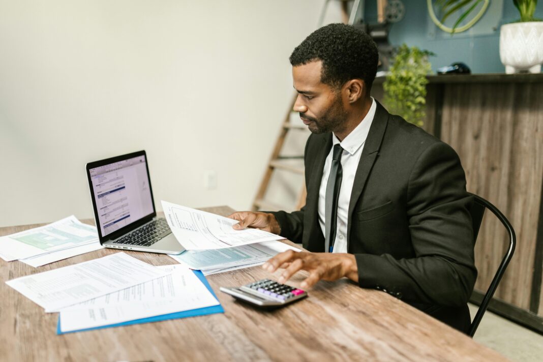 man-working-at-office-desk-with-laptop-and-phone