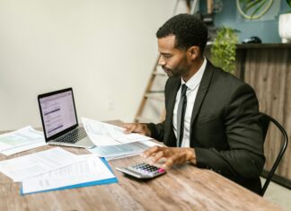 How Charities And NGOs Use VoIP To Cut Operational Costs man-working-at-office-desk-with-laptop-and-phone