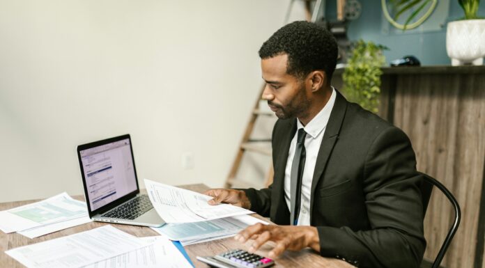 How Charities And NGOs Use VoIP To Cut Operational Costs man-working-at-office-desk-with-laptop-and-phone