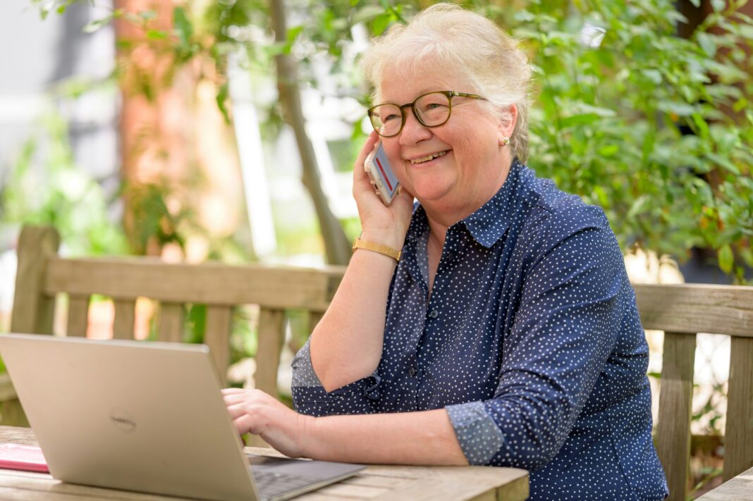 senior-woman-on-laptop-using-voip-phone-at-home