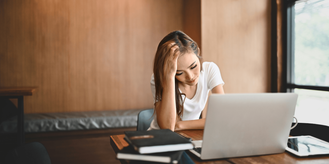 a-frustrated-woman-sitting-with-a-laptop-while-dealing-with-a-broadband-router-dropout