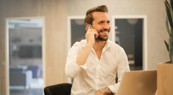 How VoIP Makes Business Communication More Flexible man-working-in-office-on-mobile-phone-laptop